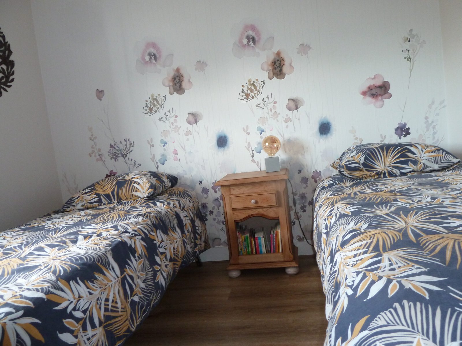 Chambre enfants avec un papier peint floral.